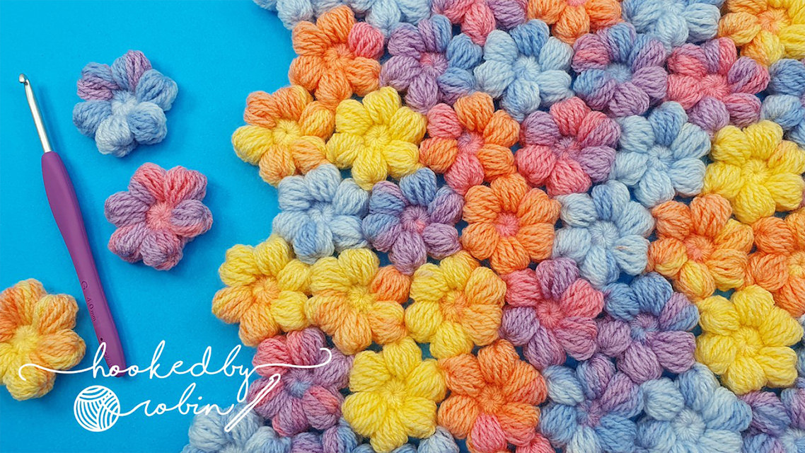 Crochet Puff Little Flowers Featured - The world of crochet is abundant with beautiful designs, but one that stands out for its charm and simplicity is the crochet puff little flower.